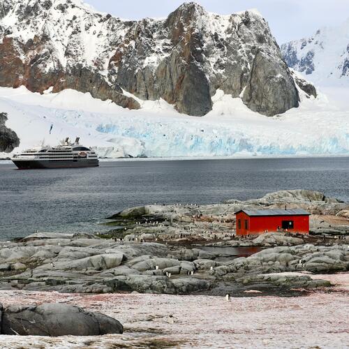 Cruiseschip Le Boreal aan de kust van Antarctica bij een rode hut