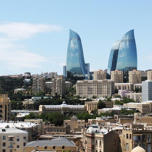 De gekromde Flame Towers steken uit boven de daken van Bakoe in Azerbeidzjan