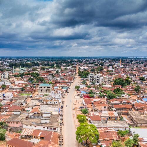 Een uitgestrekt zicht op roestende golfplaten daken in Porto-Novo, de hoofdstad van Benin