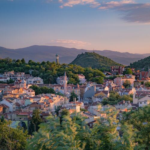Torens van kerken en moskeeën boven de daken van Plovdiv, een stad tussen de groene heuvels in Bulgarije