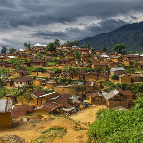 Gele huisjes met golfplaten daken bedekken een heuvel in het dorp Bitobolo in Congo