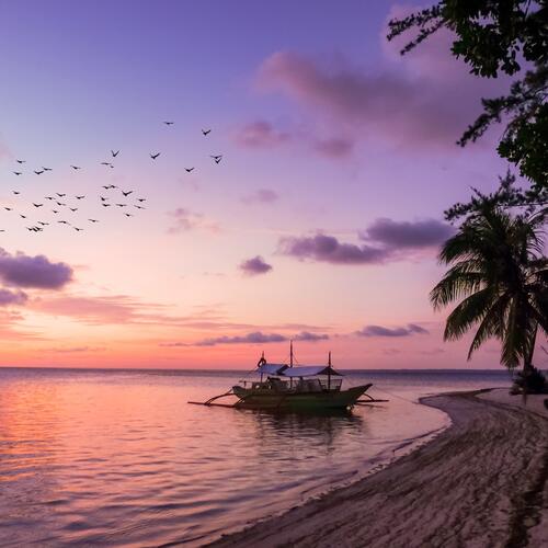 Een traditionele boot ligt aangemeerd aan het strand van Balabac, een eiland in de Filipijnen