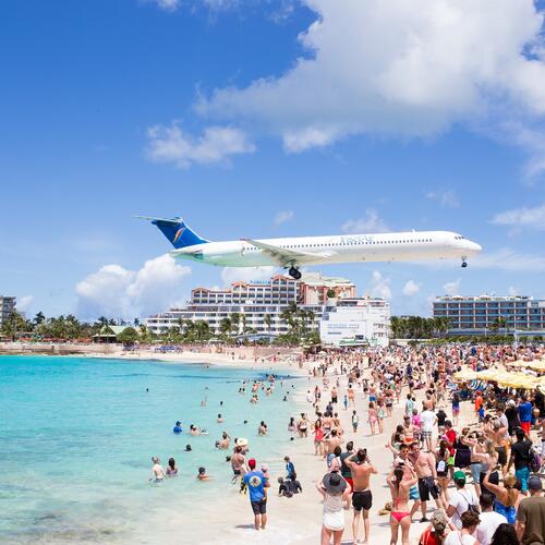 Een vliegtuig scheert over Maho Beach op Sint-Maarten.