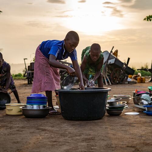 Togolese kinderen doen de vaat in Lome.