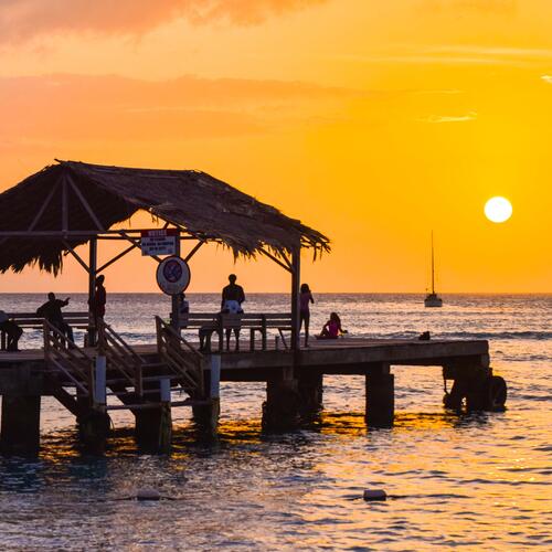 Zonsondergang boven de pier van Pigeon Point in Trinidad en Tobago.