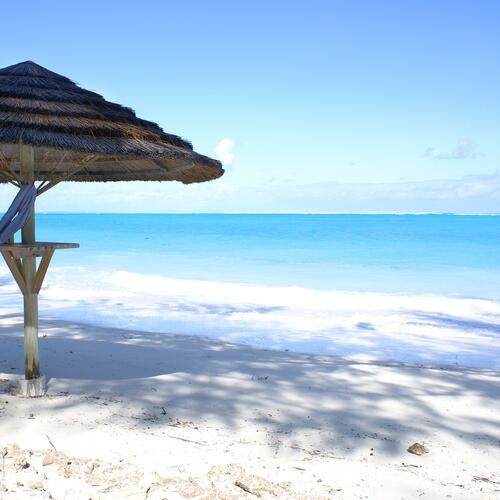 Parasol en wit zandstrand op de Turks en Caicoseilanden.