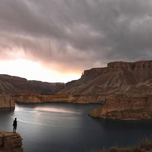 Een eenzame figuur staat aan de rand van een meer in het Band-e Amir nationaal park in de provincie Bamyan