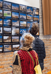 Bezoekers op Reismarkt kijken naar foto's van informant-reizigers