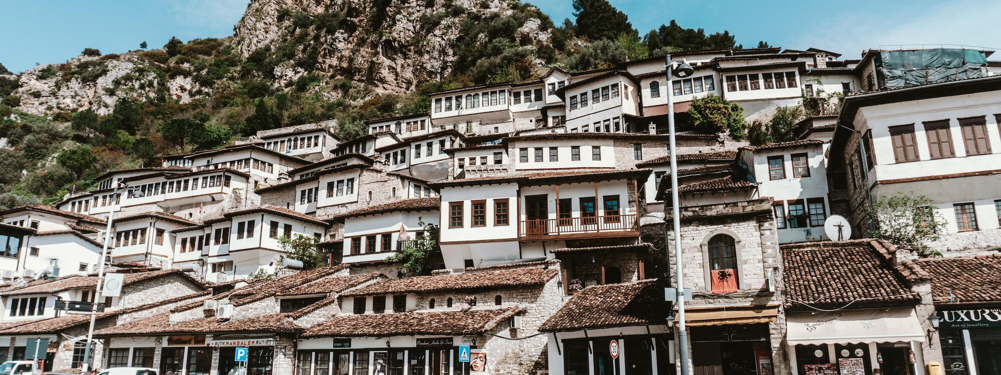 Foto van huizen op een heuvel langs een straat in Albanië
