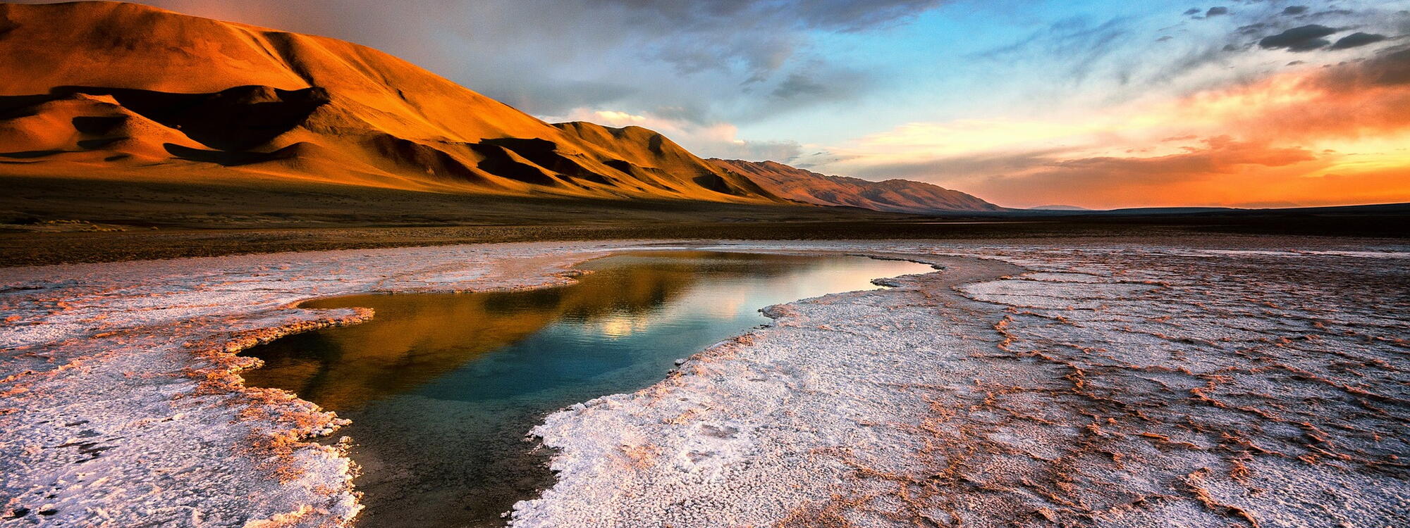 Zonsondergang bij een zoutvlakte met zicht op de Andes in Argentinië