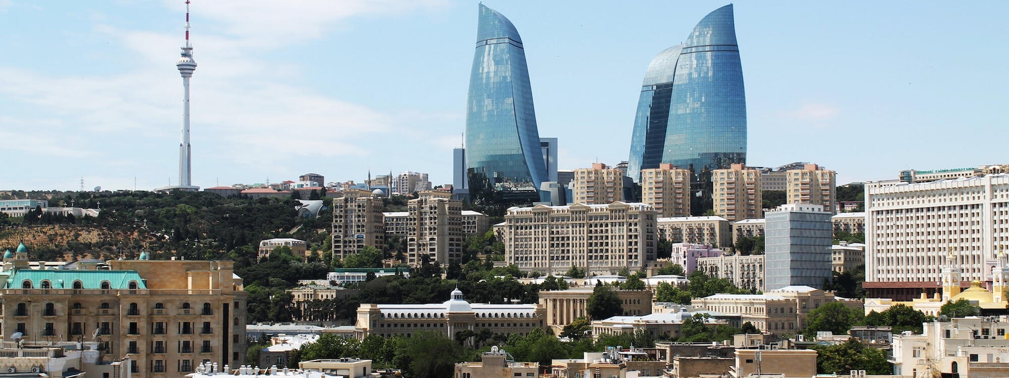 De gekromde Flame Towers steken uit boven de daken van Bakoe in Azerbeidzjan