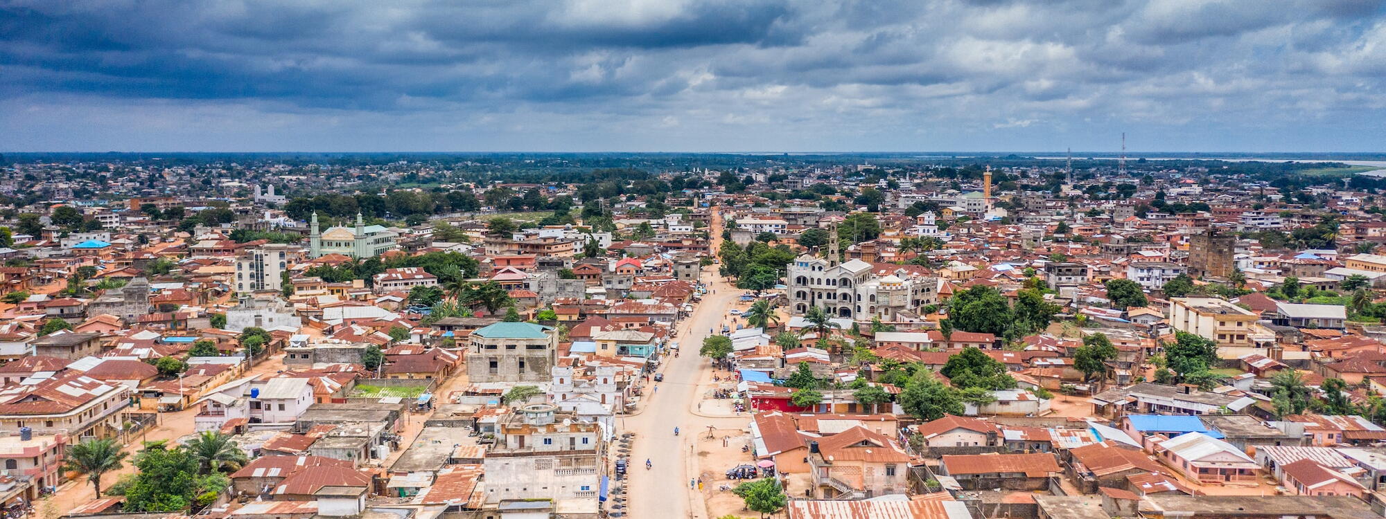 Een uitgestrekt zicht op roestende golfplaten daken in Porto-Novo, de hoofdstad van Benin