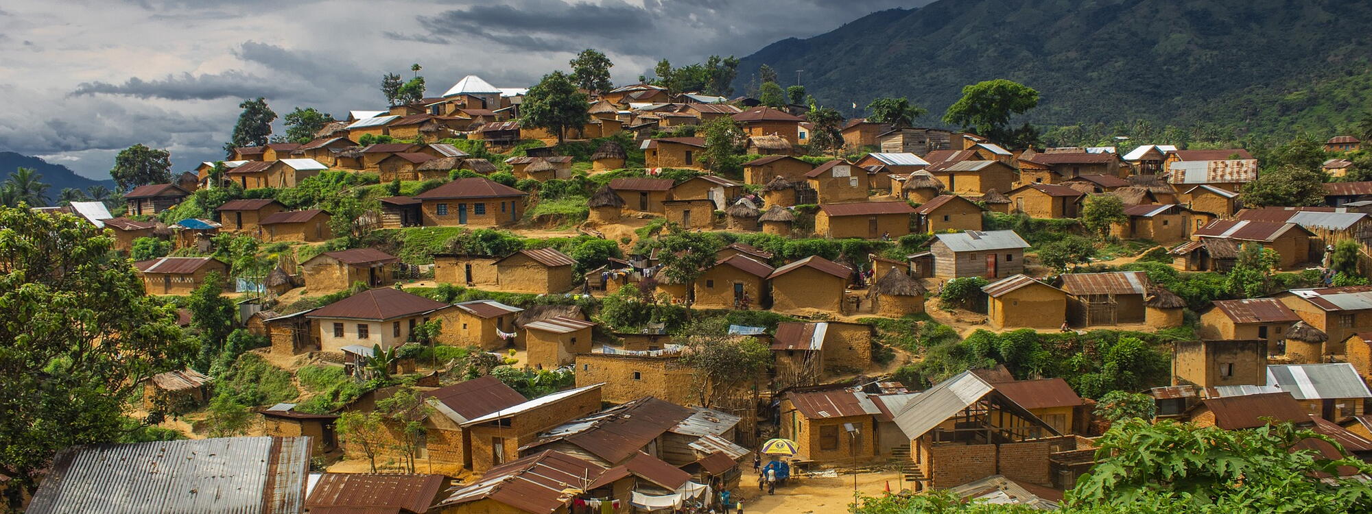 Gele huisjes met golfplaten daken bedekken een heuvel in het dorp Bitobolo in Congo