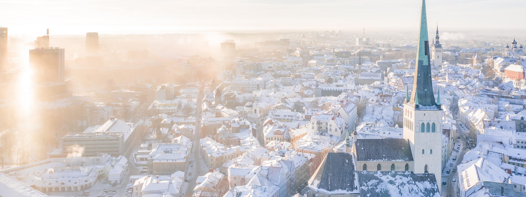 Een luchtfoto van Talinn met besneeuwde daken bij de kerk van St. Olaf. 