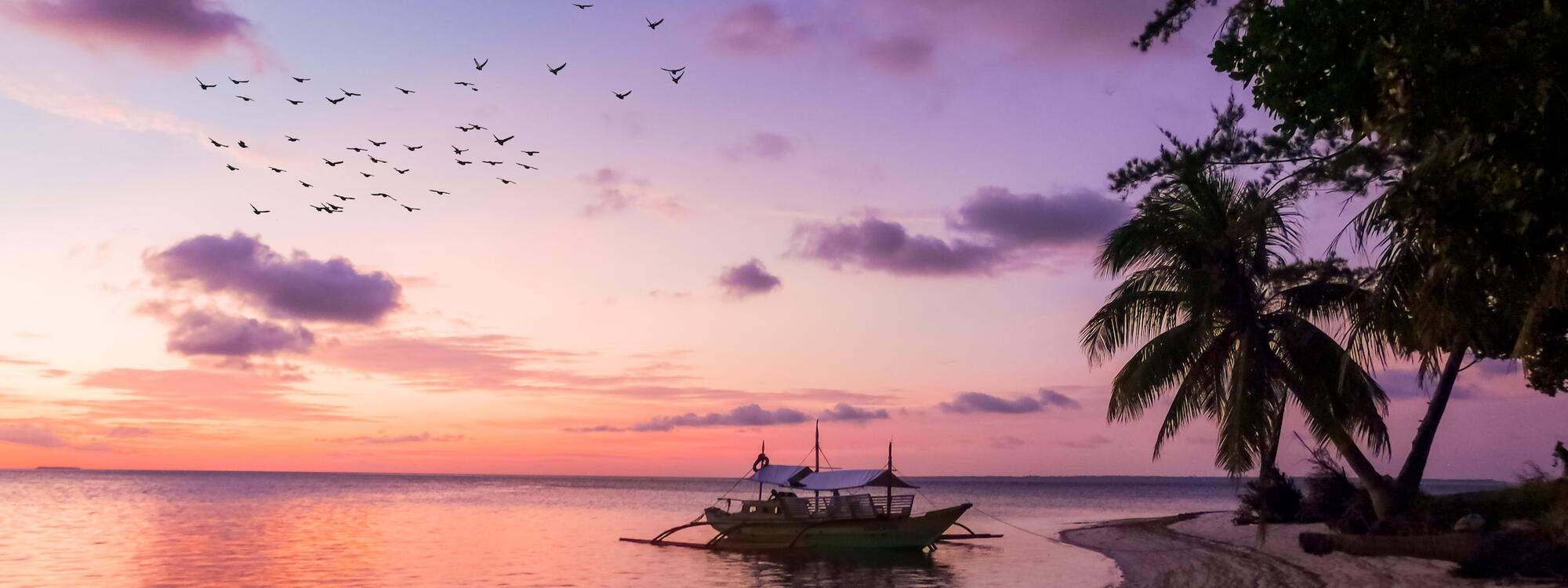 Een traditionele boot ligt aangemeerd aan het strand van Balabac, een eiland in de Filipijnen