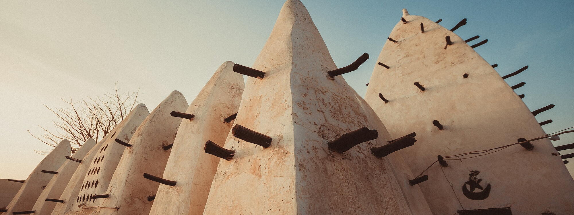 Houten balken steken uit de witte muren van de oude Larabanga-moskee in Ghana