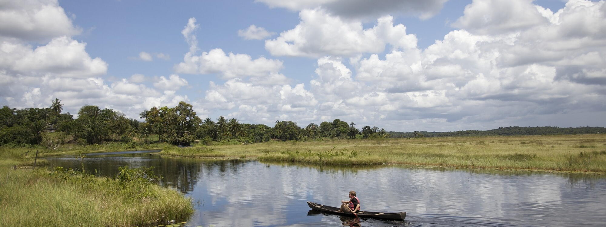Een man vaart met een kano op een rivier in Guyana