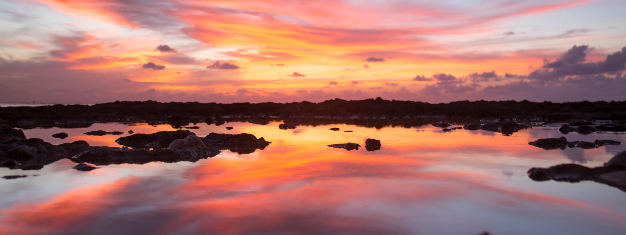 Zonsondergang vanop Seven Mile Beach op Grand Cayman.