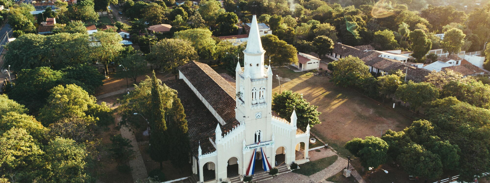 Witte kerk en omringen groen landschap in de hoofdstad Asuncion.