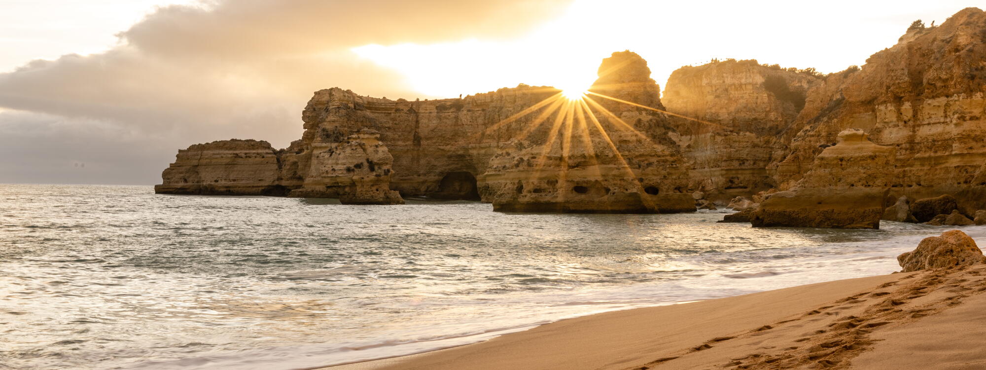 Zonsondergang boven de rotsen op Praia da Marinha in de Algarve.