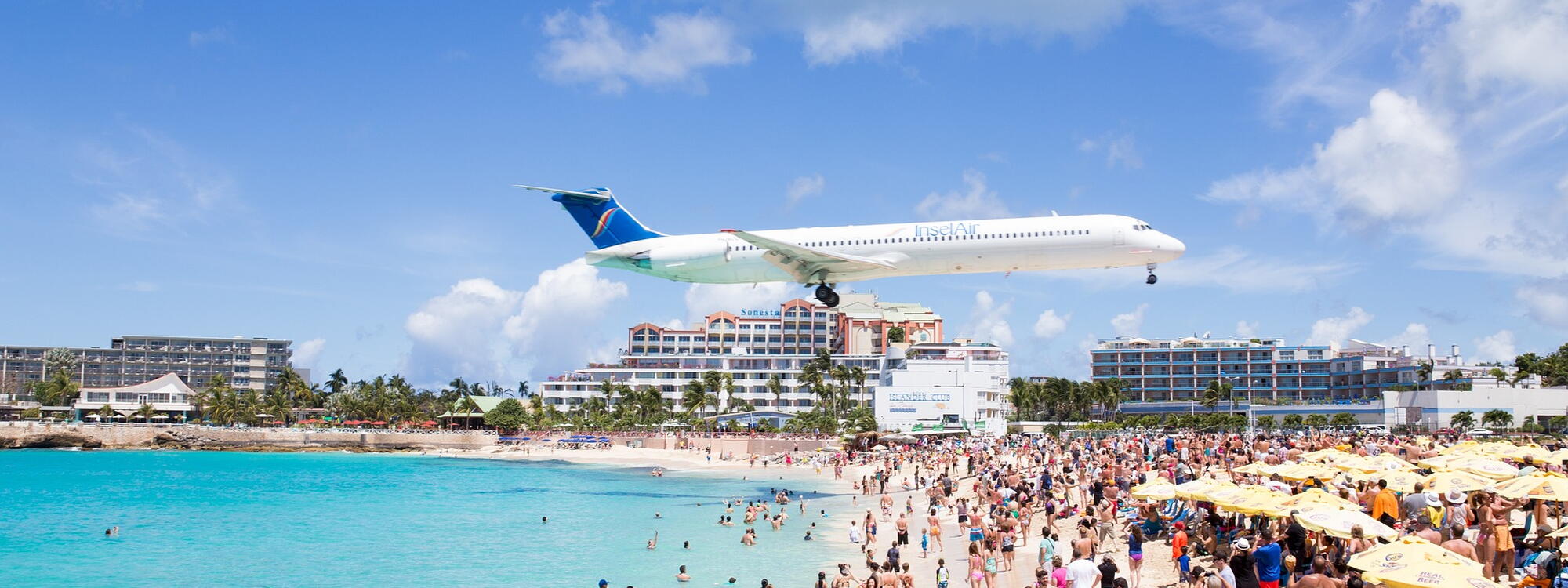 Een vliegtuig scheert over Maho Beach op Sint-Maarten.
