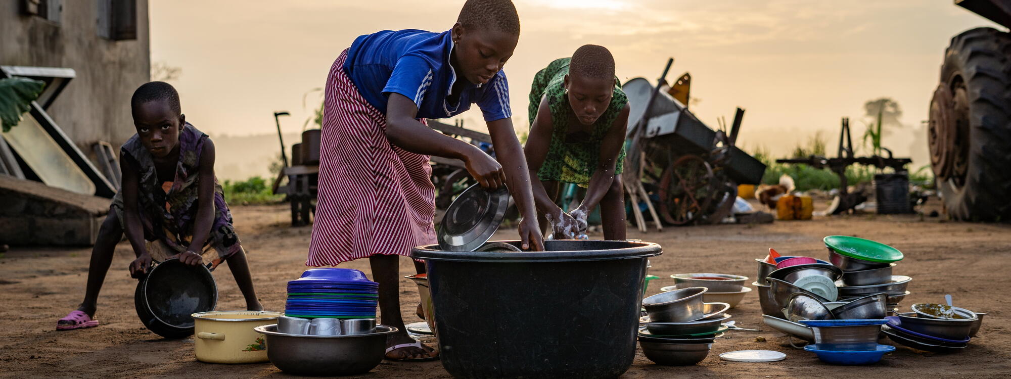 Togolese kinderen doen de vaat in Lome.