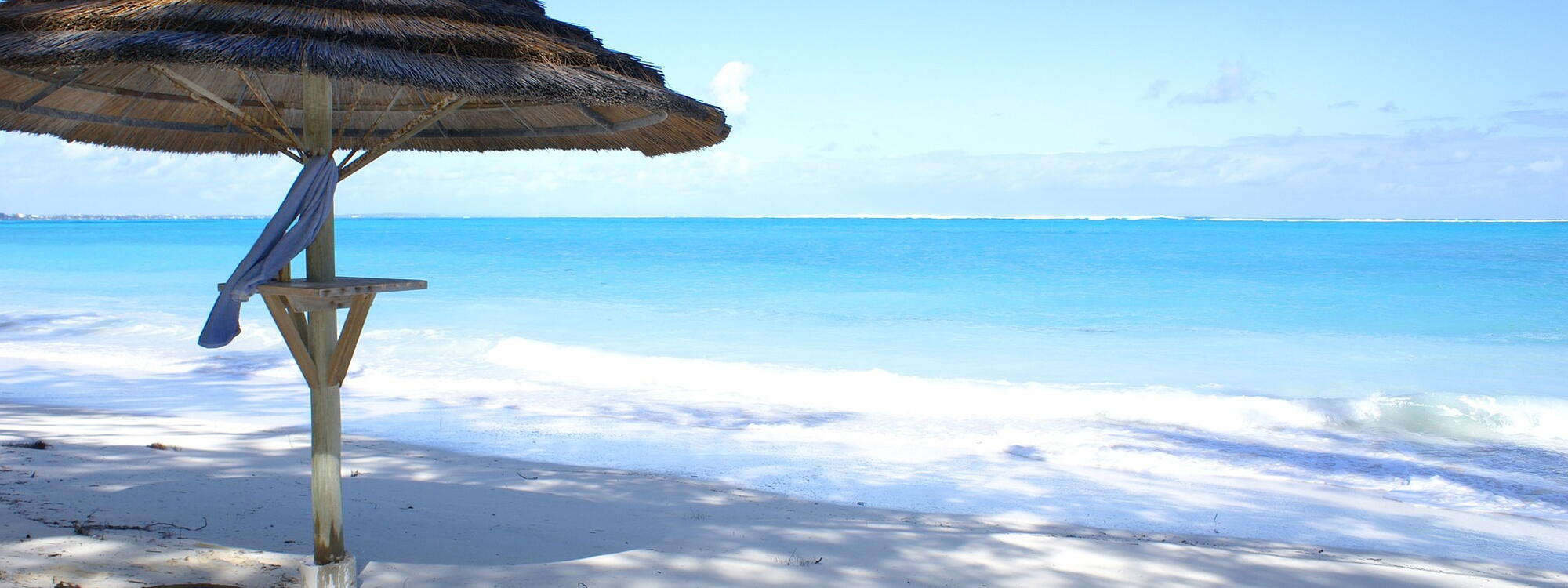 Parasol en wit zandstrand op de Turks en Caicoseilanden.