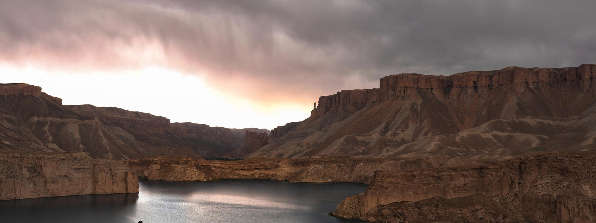 Een eenzame figuur staat aan de rand van een meer in het Band-e Amir nationaal park in de provincie Bamyan